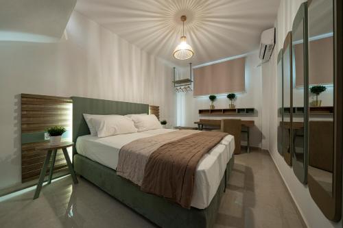 a bedroom with a large bed and a kitchen at Hermes Design Suites in Iraklitsa