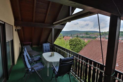 a balcony with a table and chairs and a view at Ferienwohnung Moemlingtal in Momlingen