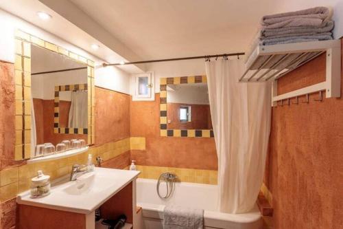 W łazience znajduje się wanna, umywalka i lustro. w obiekcie La maison de Tao w Aix-en-Provence