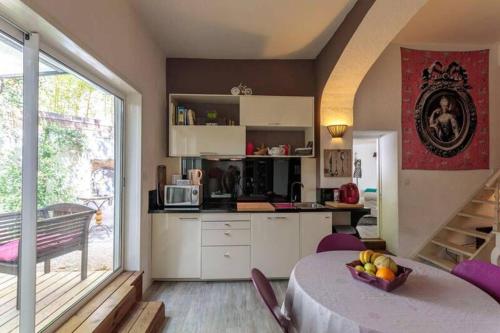 une cuisine avec une table avec un bol de fruits dessus dans l'établissement La maison de Tao, à Aix-en-Provence