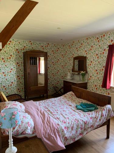 a bedroom with a bed and a dresser and a mirror at B&B De Kaagse Koe in Huigsloot