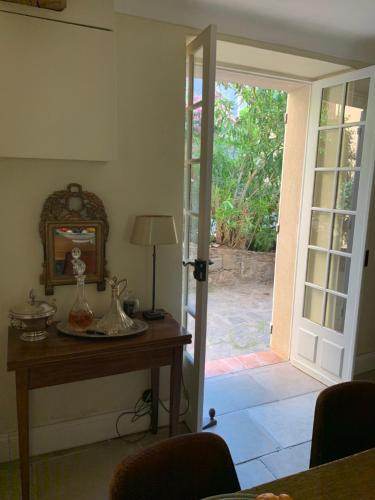 a room with a table and a door to a patio at L'aile du Chateau in Ramatuelle