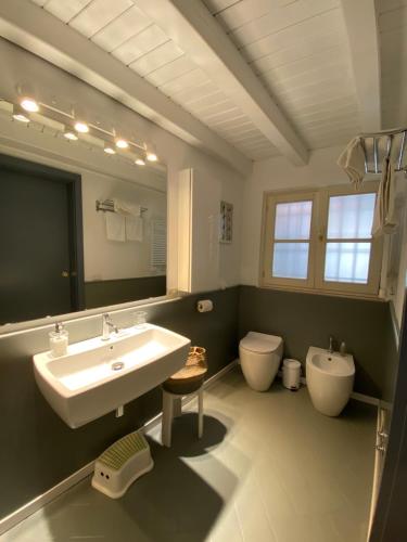 a bathroom with a sink and a toilet and a mirror at La Casetta del Porto in Sulzano