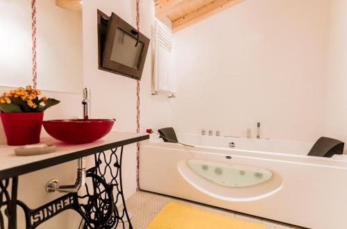 baño con bañera y TV en la pared en Huerto San Antonio, en La Cabrera