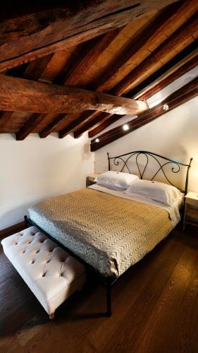 a bedroom with a bed with a bench in it at La Corte Dei Sogni B&B in Modena