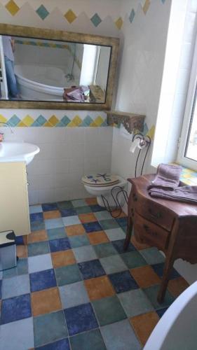 La salle de bains est pourvue d'un lavabo, de toilettes et d'une table. dans l'établissement La Ferme aux portes de Montauban - Avec piscine, à Albias