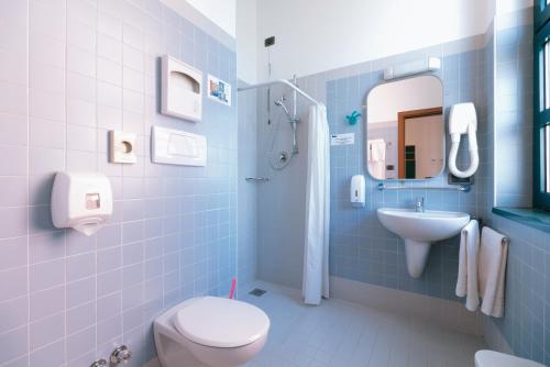 a blue bathroom with a toilet and a sink at Open011 in Turin