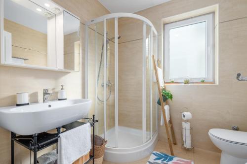 uma casa de banho com um chuveiro, um lavatório e um WC. em Apartment Andrea em Poreč