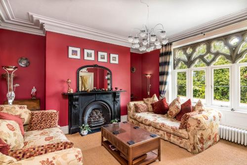 a living room with red walls and a fireplace at Ffarm Country House in Abergele