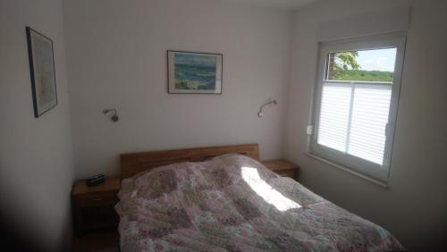 a bedroom with a bed and a window at Nordsee-Brise in Dornumersiel