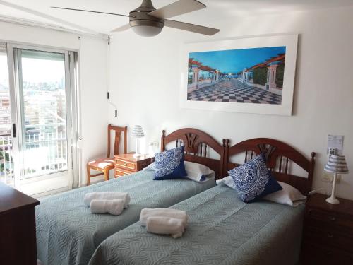 um quarto com 2 camas e uma ventoinha de tecto em Torresol em Benidorm