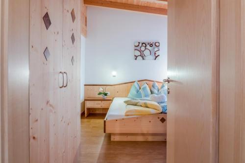 a bedroom with a bed with blue pillows at Hofschenke Pfeiftal - Bergwiese in San Martino