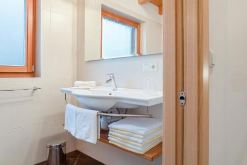 een badkamer met een wastafel, een spiegel en handdoeken bij Hofschenke Pfeiftal - Bergwiese in San Martino