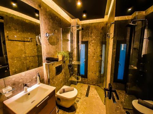 a bathroom with a sink and a toilet and a sink at Ataraxia Luxury Suite Acharavi in Acharavi