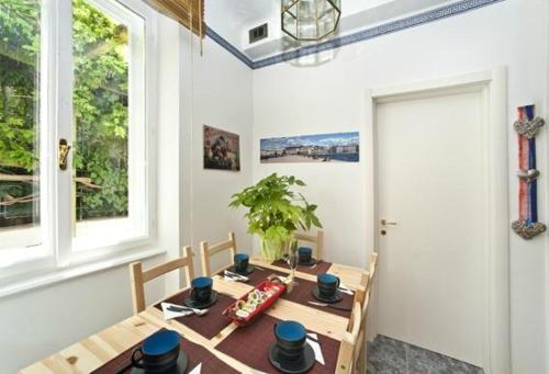 een eetkamer met een tafel en twee ramen bij Bed and breakfast Grim in Trieste