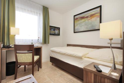 una camera d'albergo con un letto, una scrivania e una sedia di Hotel-Linde-Restaurant Monika Bosch und Martin Bosch GbR a Heidenheim an der Brenz