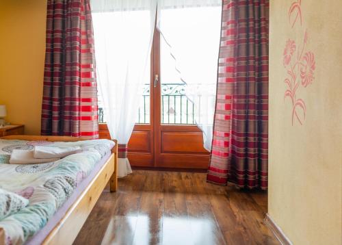 a bedroom with a bed and a window with curtains at U Repy in Bańska