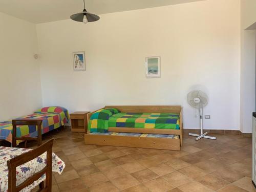 a bedroom with two beds and a table and a fan at Tenuta Punta della Suina in Gallipoli