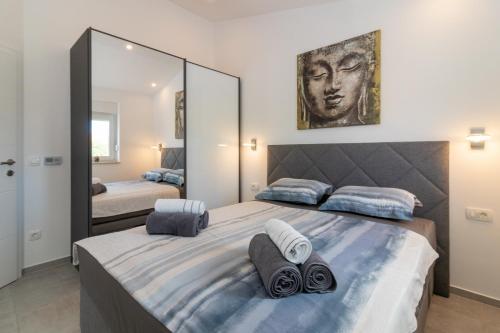a bedroom with a large bed and a large mirror at Holiday - Therapy in Krk