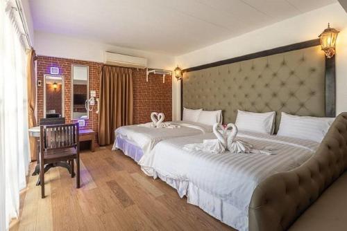 een hotelkamer met 2 bedden en handdoeken erop bij Sudyod Apartment in Bangkok