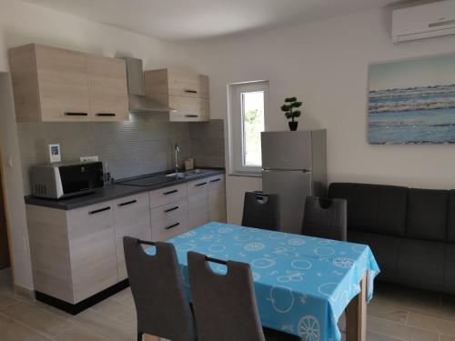 cocina y comedor con mesa y sofá en Apartments Jurandvor en Baška