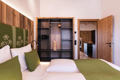a bedroom with a white bed with green pillows at Michelerhof - kinderfreie Unterkunft in Lavant