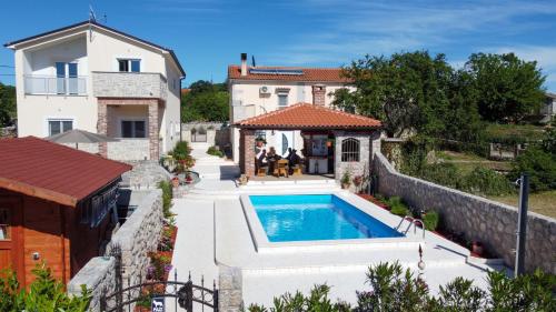 una villa con piscina di fronte a una casa di Holiday - Therapy a Krk