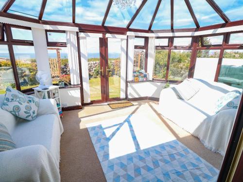 a living room with a white couch and a window at Goetra in Harlech