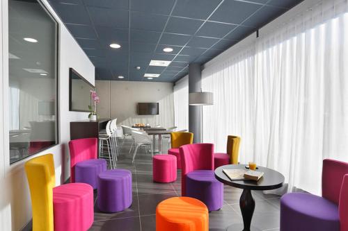 une salle d'attente avec des chaises colorées et une table dans l'établissement Résidence Nemea Nancy Campus, à Nancy