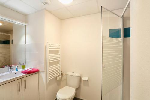 une salle de bain avec toilettes et douche en verre dans l'établissement Résidence Nemea Nancy Campus, à Nancy