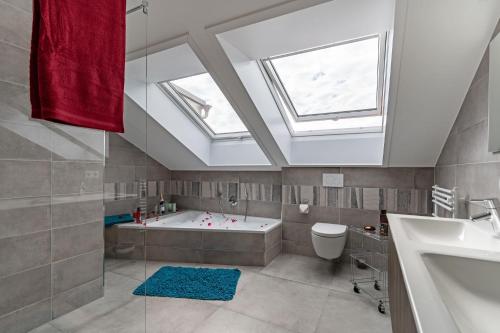 a bathroom with a bath tub and a skylight at Grünten-Chalet in Oy-Mittelberg