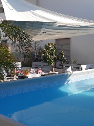 una piscina con un tavolo con piante di Residence San Vito a Mazara del Vallo