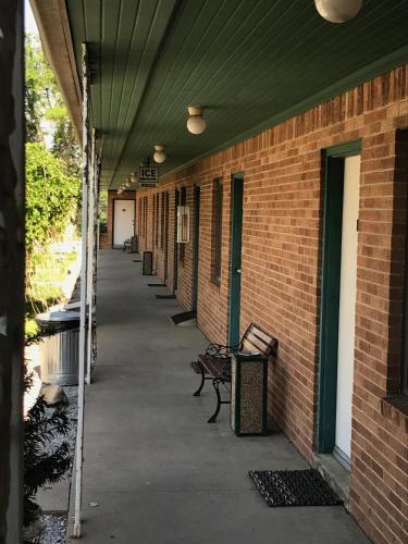 an empty hallway with benches on a brick building at The Evergreen Motel in Kansas in Pratt