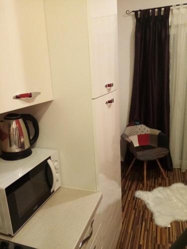 a small kitchen with a microwave and a chair at Tomena apartments in Trogir