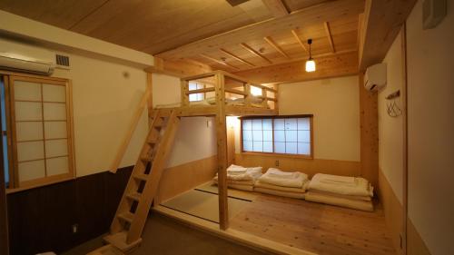a room with a bunk bed and a ladder at Poly Hostel 2 Namba in Osaka