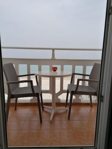 a table and two chairs on a balcony at Lefteris Rooms in Kokkari
