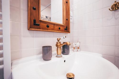 a bathroom sink with a faucet and a mirror at Pension Fialka in Český Krumlov