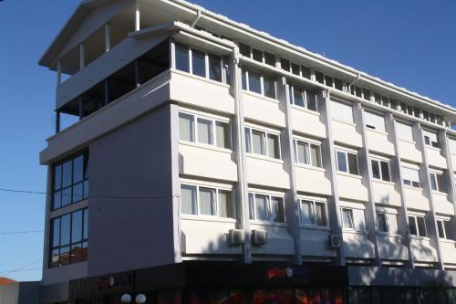 un edificio con facciata bianca di Rooms S&S Milicevic u strogom centru Aleksandrovca ad Aleksandrovac