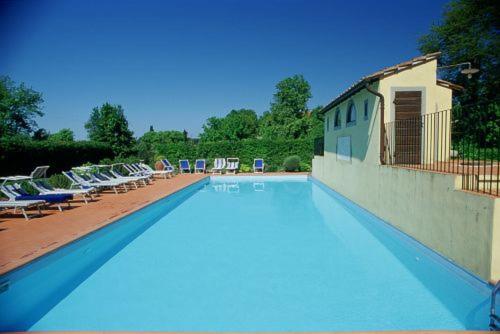 une grande piscine avec des chaises longues dans l'établissement Fattoria di Migliarino, à Migliarino