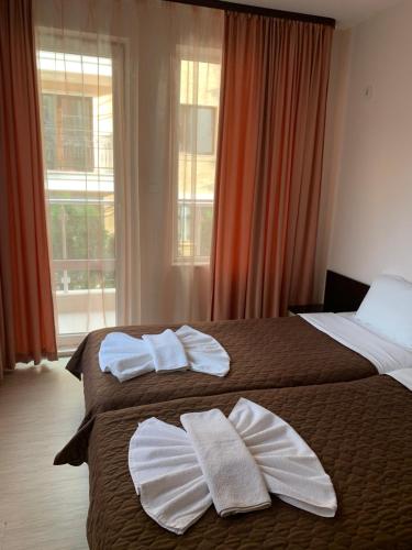 two beds in a hotel room with towels on them at Hotel Topalovi in Nesebar
