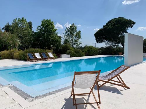 a swimming pool with lounge chairs next to it at Casas do Sal in Alcácer do Sal
