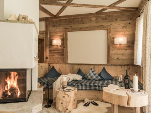 a living room with a couch and a fireplace at Hüttendorf Ladizium in Ladis