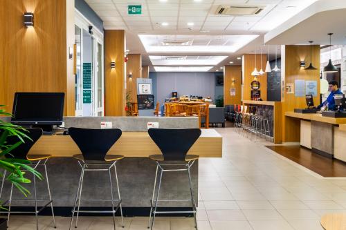 a lobby with a counter and stools in a store at ibis Ourinhos in Ourinhos