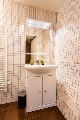 une salle de bain avec un lavabo blanc et un miroir dans l'établissement Wonderful home in PARIS, à Paris