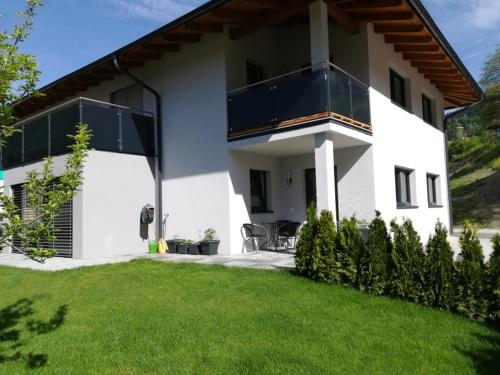 a white house with a lawn in front of it at Appartement Gschwandtner in Eben im Pongau