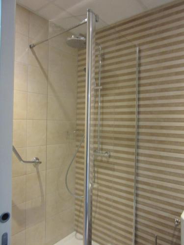 W łazience znajduje się prysznic ze szklanymi drzwiami. w obiekcie Hotel de la Londaine w mieście Champagnole