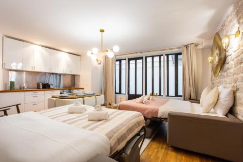 Cet appartement comprend une chambre avec deux lits et une cuisine avec des fenêtres. dans l'établissement Wonderful home in PARIS, à Paris