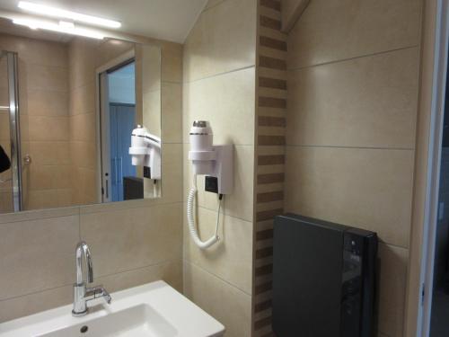 une salle de bain avec un lavabo et un miroir dans l'établissement Hotel de la Londaine, à Champagnole