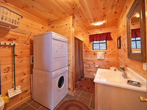 baño con nevera y fregadero en una cabaña de madera en Caught Ya Peek'n en Sevierville