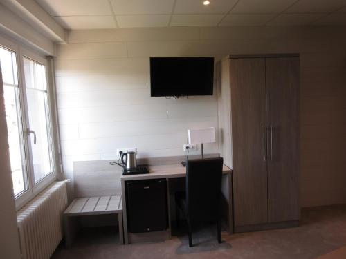 シャンパニョルにあるHotel de la Londaineのデスク、壁掛けテレビが備わる客室です。